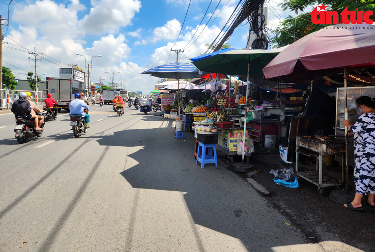 Hàng quán lấn chiếm lòng lề đường trên Quốc lộ 13.